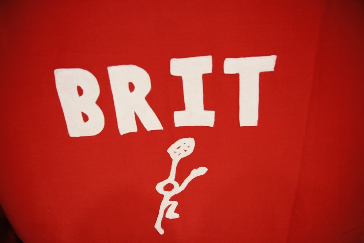 A tapestry with the BRIT man logo, in white